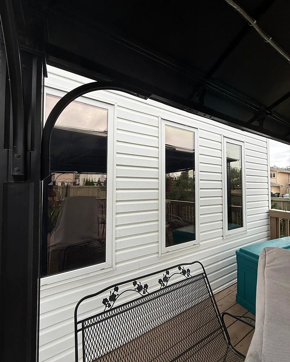 Row of patio windows with a reflective finish beside a covered deck