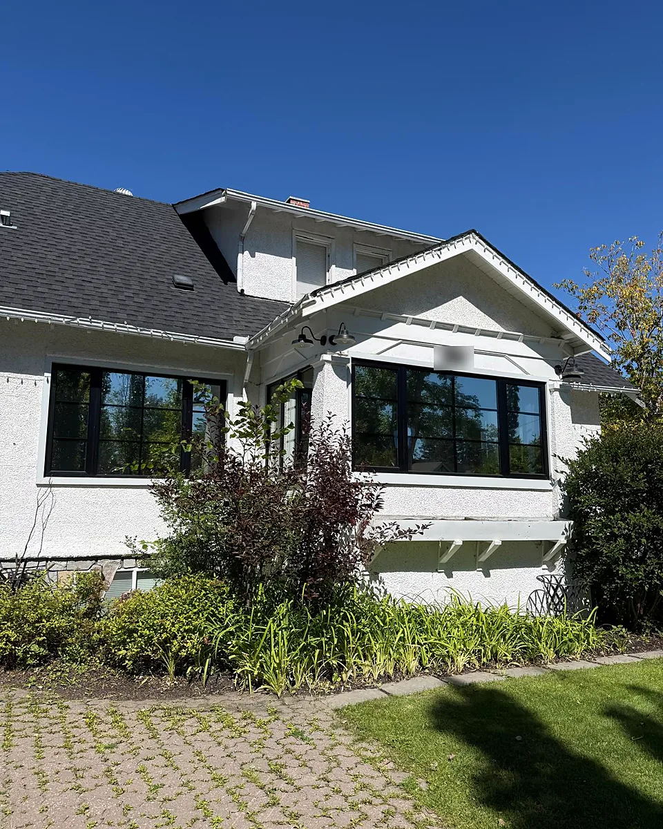 White craftsman-style home with dark tinted front windows