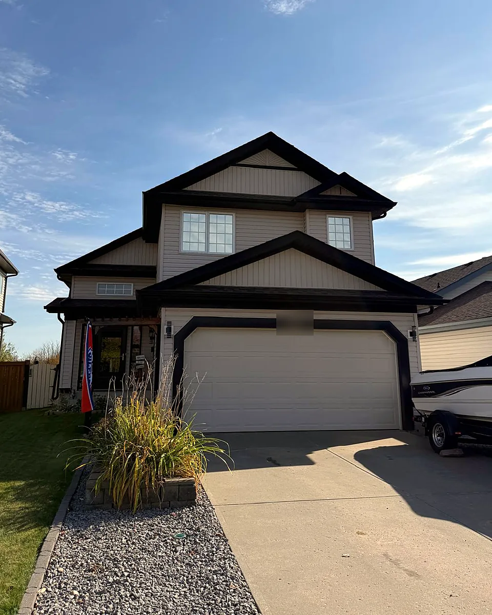 Two-story sided home with a double garage and tinted front windows